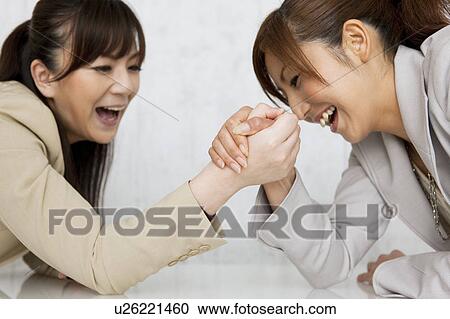 Stock Image - Businesswomen Arm Wrestling. Fotosearch