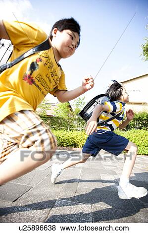 Stock Photo - Elementary school boys running, Japan. Fotosearch