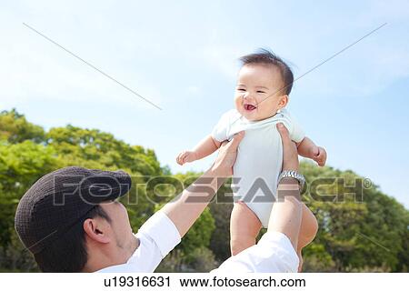 Stock Image - Father Holding Baby Boy Aloft. Fotosearch