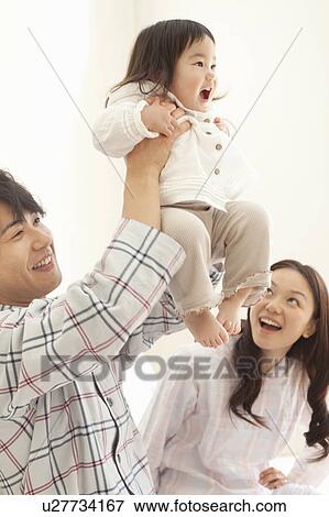 Father Holding Baby Girl Aloft, Mother Watching View Large Photo Image Stock Photo - Father Holding Baby Girl Aloft, Mother Watching. Fotosearch