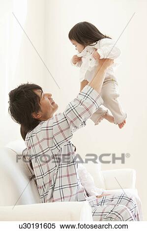 Stock Photography - Father Holding Baby Girl Aloft. Fotosearch