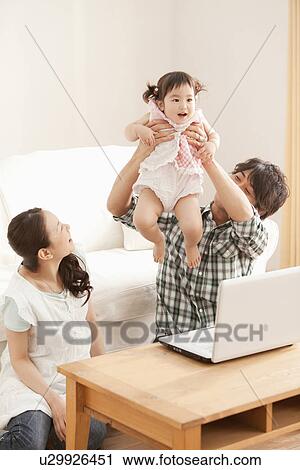 Father Holding Baby Girl Up, Mother Watching View Large Photo Image Stock Image - Father Holding Baby Girl Up, Mother Watching. Fotosearch