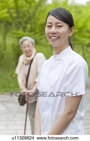 Healthcare worker and senior woman looking at camera, Tokyo Prefecture, Honshu, Japan View Large Photo Image Picture - Healthcare worker and senior woman looking at camera, Tokyo Prefecture, Honshu, Japan. Fotosearch