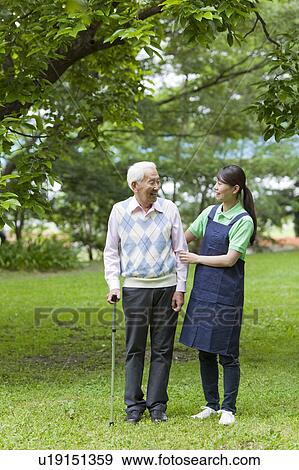 Healthcare worker helping senior man with cane, Tokyo Prefecture, Honshu, Japan View Large Photo Image Stock Photo - Healthcare worker helping senior man with cane, Tokyo Prefecture, Honshu, Japan. Fotosearch