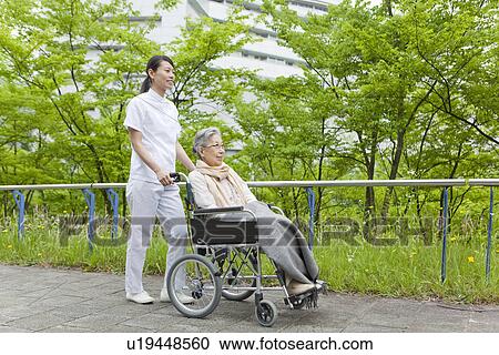 Healthcare worker pushing senior woman in wheelchair, Kanagawa Prefecture, Honshu, Japan View Large Photo Image Stock Image - Healthcare worker pushing senior woman in wheelchair, Kanagawa Prefecture, Honshu, Japan. Fotosearch