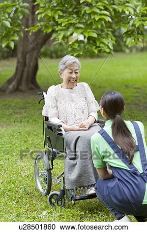 Healthcare worker talking to senior woman in wheelchair, Tokyo Prefecture, Honshu, Japan View Large Photo Image Stock Image - Healthcare worker talking to senior woman in wheelchair, Tokyo Prefecture, Honshu, Japan. Fotosearch