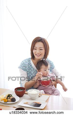 Picture - Mid Adult Mother Feeding Baby Girl. Fotosearch