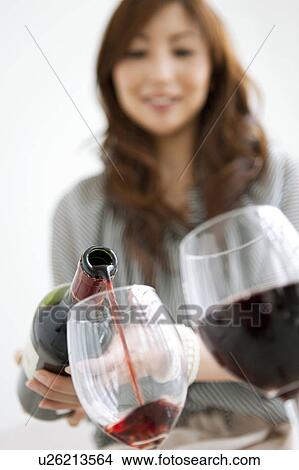Picture - Mid Adult Woman Pouring Wine. Fotosearch