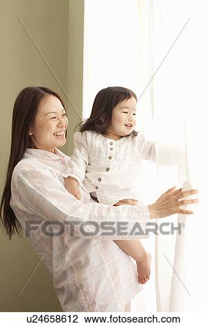 Stock Image - Mother and Daughter Looking Through Window. Fotosearch