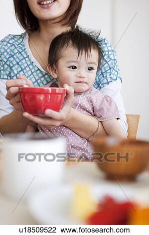 Stock Image - Mother Feeding Baby Girl. Fotosearch