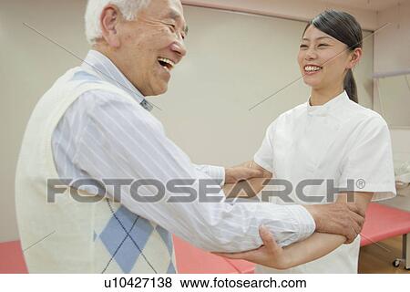 Stock Photo - Nurse helping a senior man walk, Kanagawa Prefecture, Honshu, Japan. Fotosearch