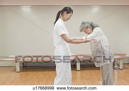 Nurse helping a senior woman walk, Kanagawa Prefecture, Honshu, Japan View Large Photo Image Stock Photo - Nurse helping a senior woman walk, Kanagawa Prefecture, Honshu, Japan. Fotosearch
