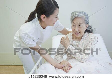 Nurse helping up a senior woman in bed, Kanagawa Prefecture, Honshu, Japan View Large Photo Image Stock Photo - Nurse helping up a senior woman in bed, Kanagawa Prefecture, Honshu, Japan. Fotosearch