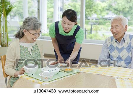 Nurse Serving Food to Senior Woman View Large Photo Image Stock Photo - Nurse Serving Food to Senior Woman. Fotosearch
