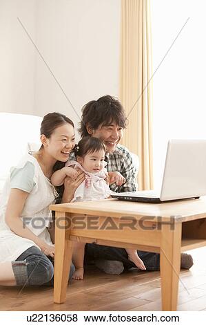 Stock Photo - Parents and Baby Girl Using Laptop. Fotosearch