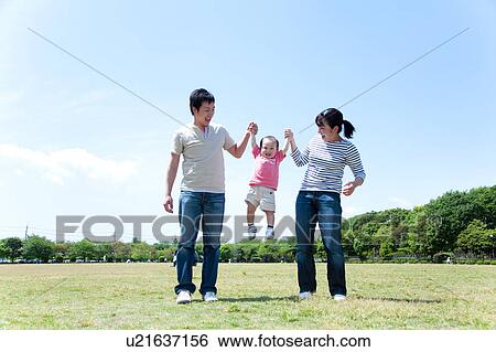 Stock Photograph - Parents Lifting Baby Boy From Hands. Fotosearch