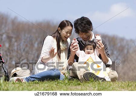 Stock Photo - Parents with Baby Girl in Park. Fotosearch