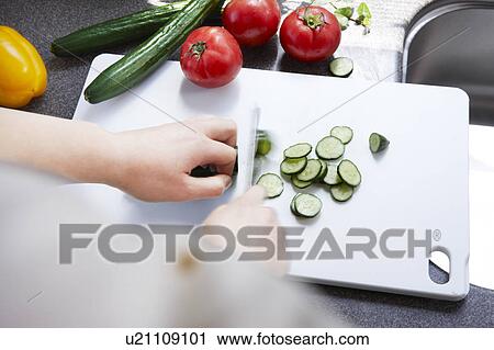 Stock Image - Person Chopping Cucumber. Fotosearch