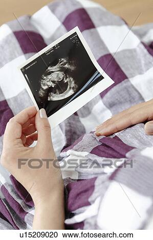 Stock Image - Pregnant Woman Holding Ultrasound Scan. Fotosearch