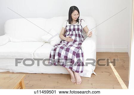 Pregnant Woman Using Smart Phone on Sofa View Large Photo Image Stock Image - Pregnant Woman Using Smart Phone on Sofa. Fotosearch