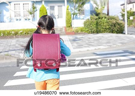 Stock Image - Rear view of a schoolgirl walking, Japan. Fotosearch