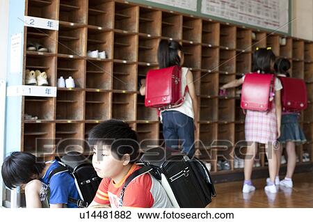Stock Image - Schoolchildren Putting On Shoes. Fotosearch