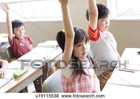 Schoolchildren Raising Arms in Classroom View Large Photo Image Stock Photo - Schoolchildren Raising Arms in Classroom. Fotosearch
