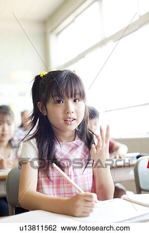Stock Image - Schoolgirl Calculating in Classroom. Fotosearch