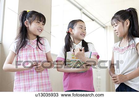 Stock Image - Schoolgirls Talking in Corridor. Fotosearch