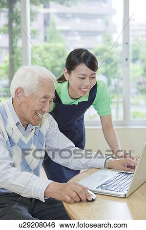 Senior man and nurse using a laptop, Kanagawa Prefecture, Honshu, Japan View Large Photo Image Stock Photograph - Senior man and nurse using a laptop, Kanagawa Prefecture, Honshu, Japan. Fotosearch