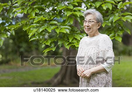 Senior woman standing and smiling, Tokyo Prefecture, Honshu, Japan View Large Photo Image Stock Photography - Senior woman standing and smiling, Tokyo Prefecture, Honshu, Japan. Fotosearch