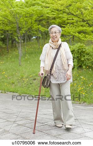 Senior woman walking with a cane, Tokyo Prefecture, Honshu, Japan View Large Photo Image Stock Photograph - Senior woman walking with a cane, Tokyo Prefecture, Honshu, Japan. Fotosearch