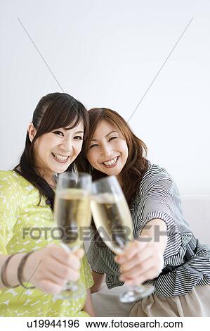 Stock Photograph - Two Female Friends Toasting with Champagne. Fotosearch