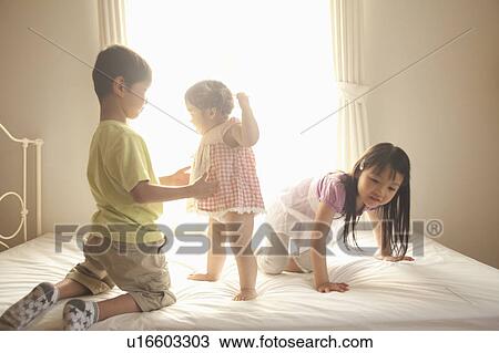 Two Girls and Boy on Bed View Large Photo Image Stock Image - Two Girls and Boy on Bed. Fotosearch