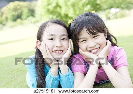 Two Girls Lying on Grass View Large Photo Image Stock Image - Two Girls Lying on Grass. Fotosearch