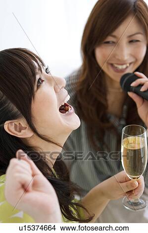 Two Women Singing Karaoke and Having Champagne View Large Photo Image Picture - Two Women Singing Karaoke and Having Champagne. Fotosearch