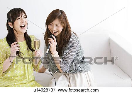 Stock Photo - Two Women Singing Karaoke. Fotosearch