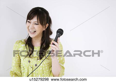 Stock Photo - Woman Singing Karaoke. Fotosearch