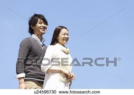 Young Couple Against Blue Sky View Large Photo Image Stock Image - Young Couple Against Blue Sky. Fotosearch