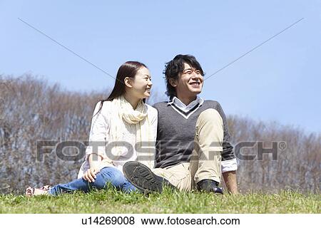 Stock Photo - Young Couple Sitting on Lawn. Fotosearch