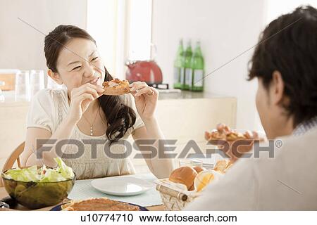 Stock Image - Young Man and Woman Eating Pizza. Fotosearch