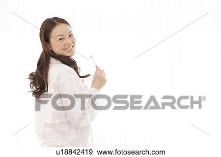 Stock Photo - Young Woman Brushing Teeth. Fotosearch