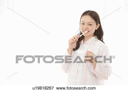 Stock Photo - Young Woman Brushing Teeth. Fotosearch