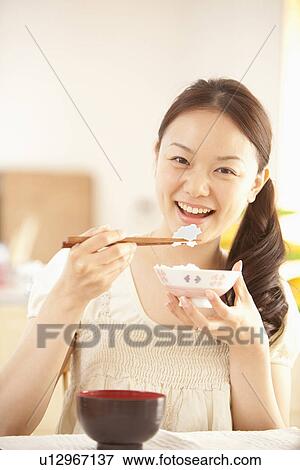 Stock Photo - Young Woman Eating Rice. Fotosearch