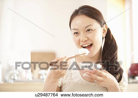Picture - Young Woman Having Rice. Fotosearch