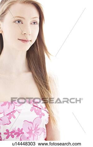 Stock Image - Young woman standing and looking away. Fotosearch