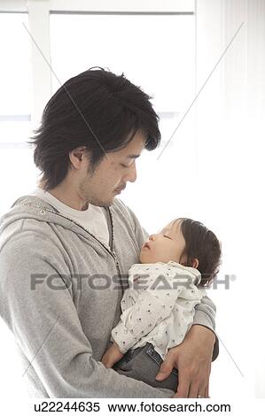 Stock Photography - Baby Boy Sleeping in Father's Arms. Fotosearch