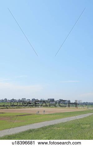 Stock Image - Blue Sky Over City, Field in Foreground. Fotosearch