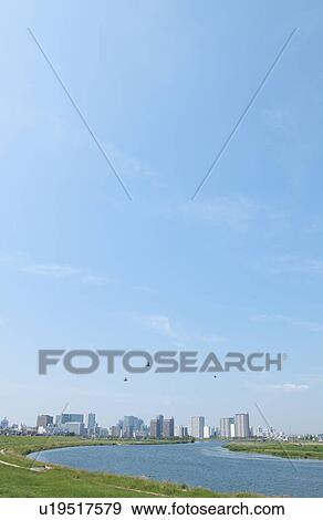 Stock Photo - Blue Sky Over City, Grass in Foreground. Fotosearch
