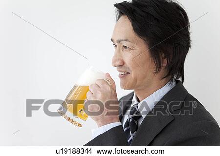 Businessman holding beer in a mug View Large Photo Image Picture - Businessman holding beer in a mug. Fotosearch